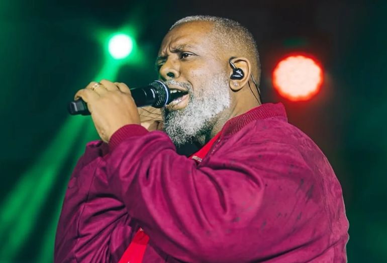 O cantor Péricles cantando, possivelmente no palco ou em um evento, falando sobre seus planos futuros.